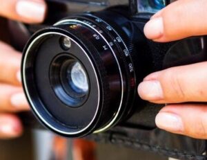 close-up-woman-holding-retro-photo-camera-Freepik